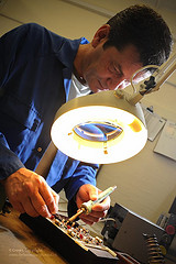 Civilian Technician Inspects Circuit Board at Army Aviation Centre Middle Wallop, by UK Ministry of Defence